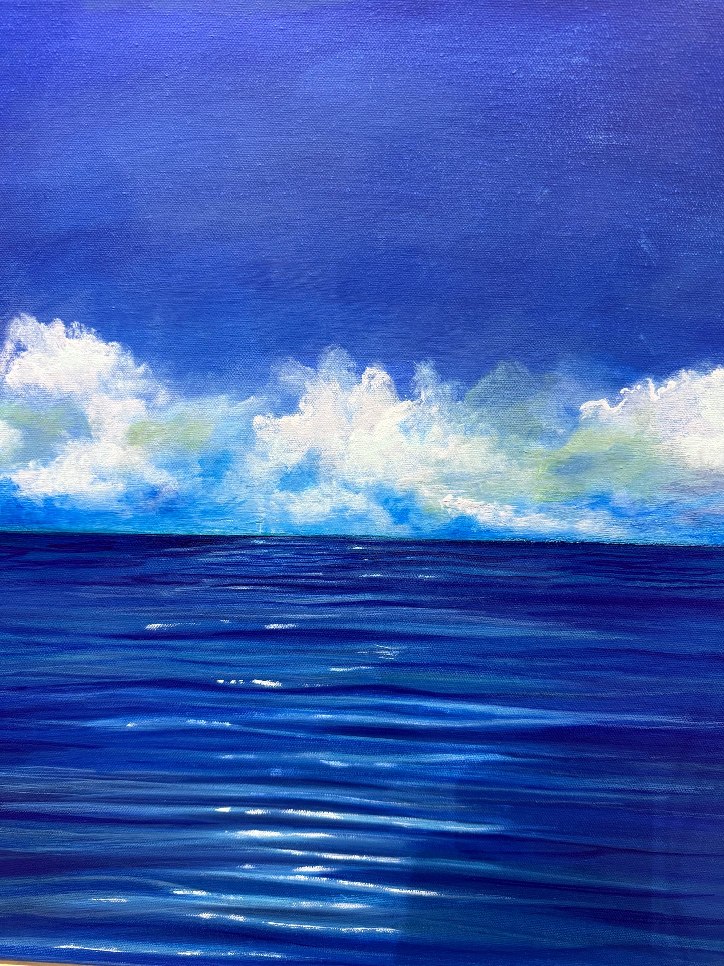 Painting of a blue ocean with white clouds in the sky