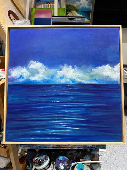 The Weight of Blue by Dallal Naser. Blue ocean with white clouds on an easel.